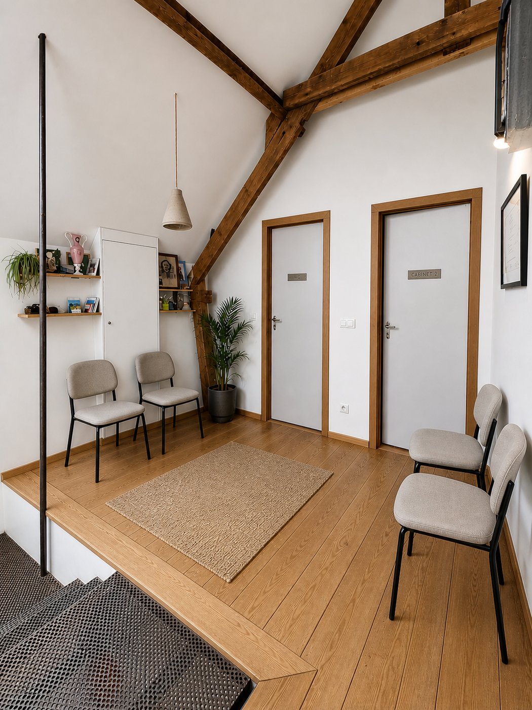 Salle d'attente sous combles avec poutres apparentes et chaises grises